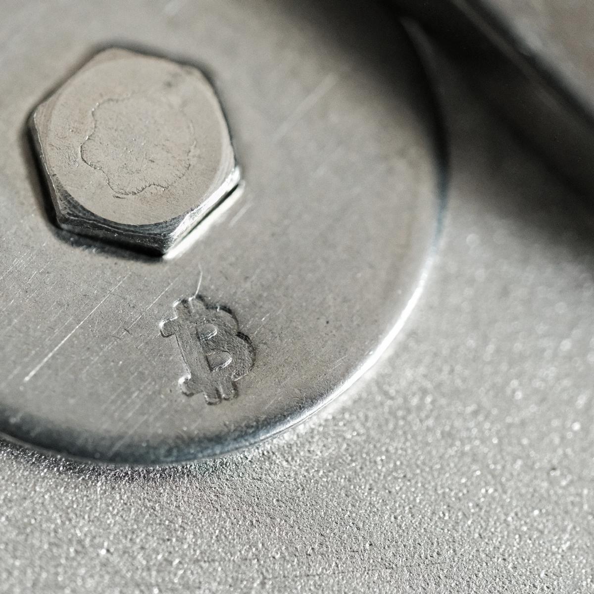 Logo Bitcoin frappé sur un écrou en acier